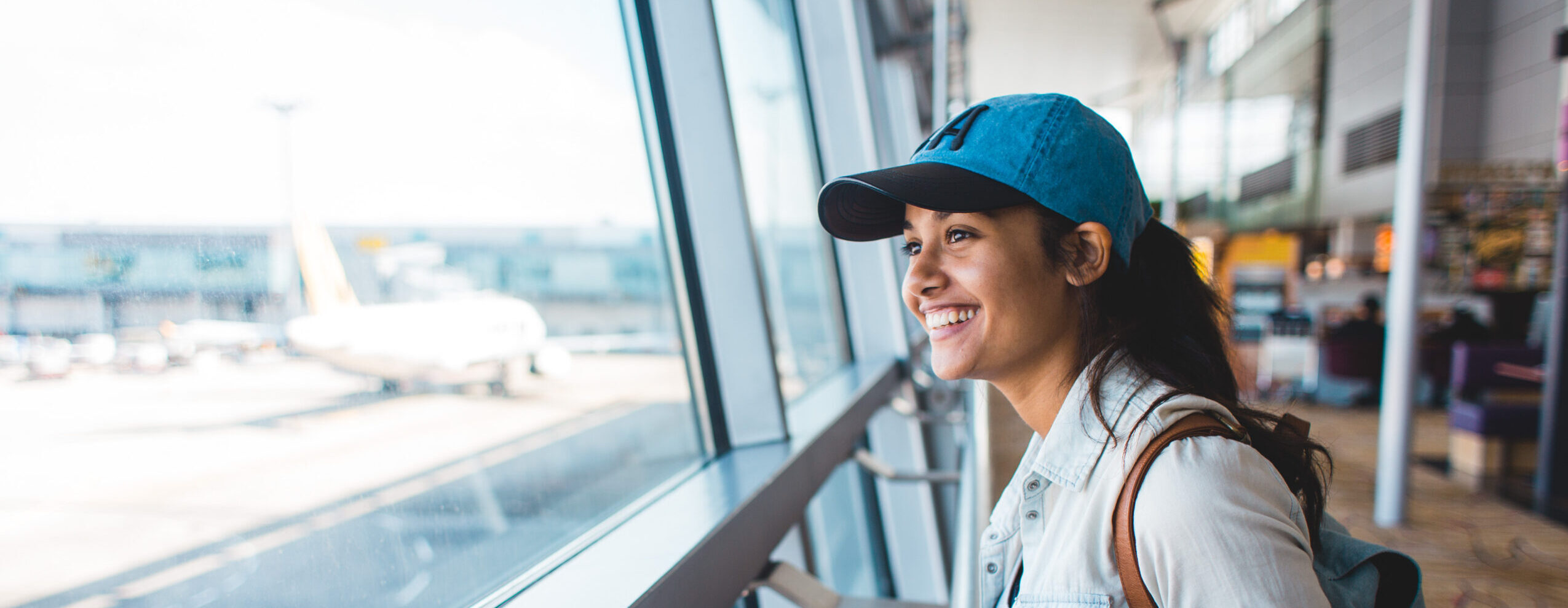 Young woman at airport waiting for airplane